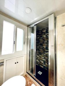 een badkamer met een douche en een glazen deur bij Cardenales in Barcelona