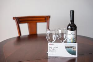 butelkę wina i dwa kieliszki wina na stole w obiekcie GuestReady - Cosy Hideaway in Vila do Conde w mieście Vila do Conde