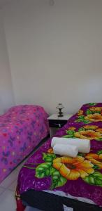 a bed with a purple blanket with flowers on it at Departamento en el centro de la ciudad in Mercedes
