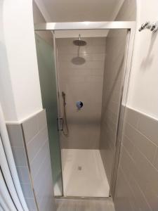 una ducha con puerta de cristal en un baño en Casa Liviya - Appartamento con vista lago, en Madonna del Sasso