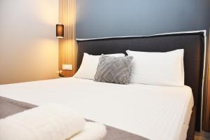 een bed met witte lakens en kussens in een kamer bij Relaxed Dream home in Chania