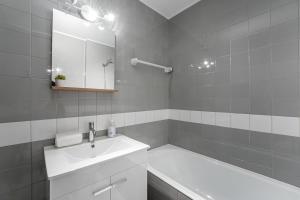 a bathroom with a sink and a mirror and a tub at GuestReady - Charm stay in Senhora da Hora in Senhora da Hora