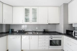 a white kitchen with white cabinets and a sink at GuestReady - Charm stay in Senhora da Hora in Senhora da Hora