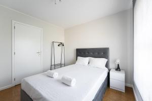 a white bedroom with a bed with two towels on it at GuestReady - Charm stay in Senhora da Hora in Senhora da Hora