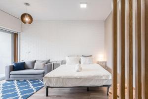 una camera con letto e divano di GuestReady - Bright Studio with balcony a Vila Nova de Gaia