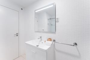 bagno bianco con lavandino e specchio di GuestReady - Bright Studio with balcony a Vila Nova de Gaia