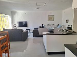 a kitchen and living room with a couch and a table at Siesta Cottage in Howick