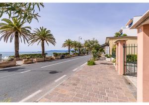 a street with palm trees on the side of the road w obiekcie Diamante Sea Apartment w mieście Varigotti