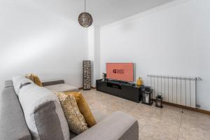 een woonkamer met een bank en een tv bij GuestReady - Rio Tinto Terrace in Rio Tinto