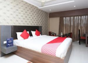 a bedroom with a large bed with red pillows at Hotel Richi Regency Bhubaneswar in Bhubaneshwar