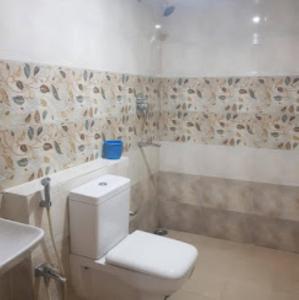 a bathroom with a white toilet and a sink at Hotel Richi Regency Bhubaneswar in Bhubaneshwar