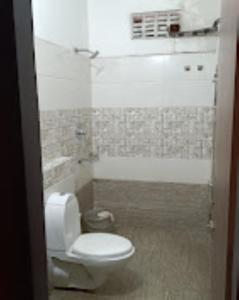 a bathroom with a white toilet and a shower at Hotel Richi Regency Bhubaneswar in Bhubaneshwar