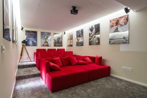 - un canapé rouge dans une pièce avec des affiches sur le mur dans l'établissement GuestReady - A fantastic retreat in Valongo, à Valongo