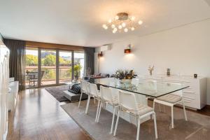 a kitchen and dining room with a glass table and chairs at GuestReady - Freixo lux with Douro River view in Porto