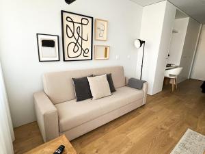 ein Wohnzimmer mit einer weißen Couch mit Kissen darauf in der Unterkunft GuestReady - Senhora da Hora stay near City Golf in Senhora da Hora