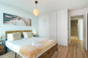 ein Schlafzimmer mit einem großen Bett mit weißen Wänden in der Unterkunft GuestReady - Blue Roof in Vila Nova de Gaia
