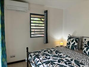 1 dormitorio con cama y ventana en Soleil,jardin et jacuzzi en Bora Bora