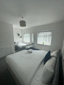 um quarto com uma grande cama branca e um sofá em Charming 2-BR Property - Sleeps 5 em Warrington