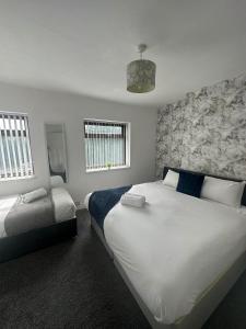 a bedroom with two beds and two windows at Charming 2-BR Property - Sleeps 5 in Warrington