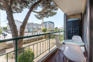 a balcony with a table and chairs and a tree at GuestReady - Shades of Blue with Balcony in Porto