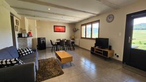 a living room with a couch and a tv and a table at Le Zell in Zellenberg