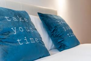 two blue pillows with the words take your time at GuestReady - Miragaia Stone Studio 2T in Porto