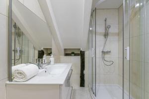 a white bathroom with a shower and a sink at GuestReady - Miragaia Stone Studio 2T in Porto