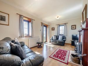 a living room with a leather couch and a television at Barnstable - Uk46888 in Kilmory