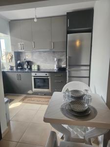a kitchen with a table and a stainless steel refrigerator at Monda Apartment in Piraeus