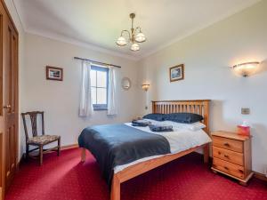 a bedroom with a bed and a chair and a window at Barnstable - Uk46888 in Kilmory