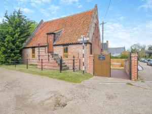 an old brick house with a wooden door at Little Barn At Bradwell Hall in Great Yarmouth