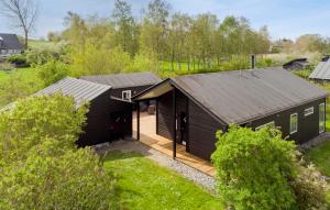 una vista aérea de una casa negra con terraza de madera en Stunning Home In Stege With Kitchen, en Stege