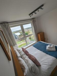 a bedroom with a bed with a large window at Skyline Plaza By Viridian Apartments in Basingstoke