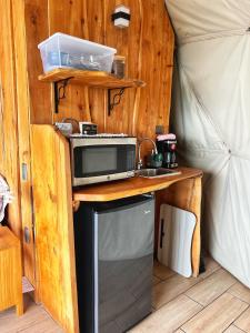 a kitchen with a microwave and a stove in a tent at Green Noise Glamping in Fraijanes