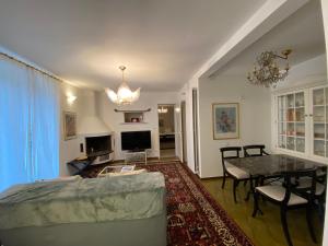 a living room with a table and a dining room at Villa Ani in Ascona