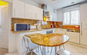 a kitchen with a table and a microwave at Awesome Home In Blonville-Sur-Mer in Blonville-sur-Mer