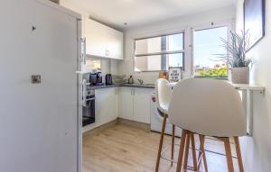 eine Küche mit weißen Schränken und einem Tisch und Stühlen in der Unterkunft Nice Apartment In El Campello With Wifi in El Campello