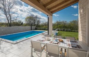 a patio with a table and chairs next to a swimming pool at Beautiful Home In Buje in Buje