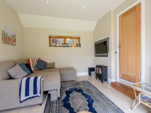 a living room with a couch and a flat screen tv at Westmoor Annexe in Hereford