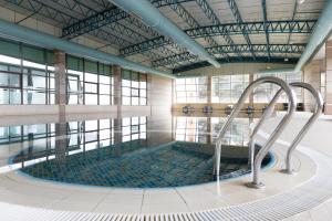a large swimming pool in a building with windows at Chinar Hotel & Spa Naftalan in Naftalan