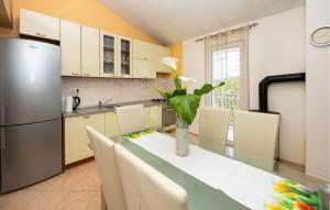 une cuisine avec une table et un vase de fleurs. dans l'établissement Cozy Home In Katuni Rubici, Prpusa With Kitchen, à Šestanovac