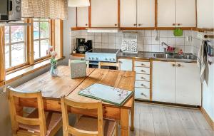 - une cuisine avec une table en bois, des chaises et un évier dans l'établissement Cozy Home In Mora With Kitchen, à Mora