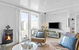 sala de estar con sofá y chimenea en Awesome Home In Pandrup With House A Panoramic View, en Rødhus