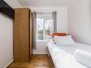 a small bedroom with a bed and a window at Holbrook House in Cambridge