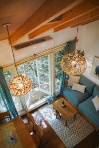 una vista aérea de una sala de estar con un sofá azul en Blue House In The Woods- Amirim en Amirim