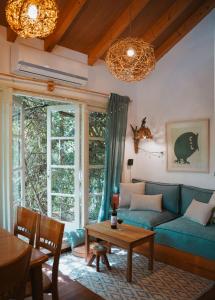 a living room with a blue couch and a table at Blue House In The Woods- Amirim in Amirim
