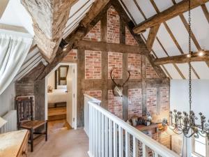 um quarto com uma parede de tijolos e uma escada em Courtyard Cottage - Uk47218 em Great Bolas