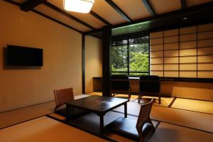 a room with a table and chairs and a window at Taikyourou in Miyazu