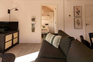 uma sala de estar com um sofá e uma televisão em Fred I Tiny House op de Veluwe em Epe