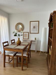 a dining room with a wooden table and chairs at Pinares de Boo in Boó de Piélagos